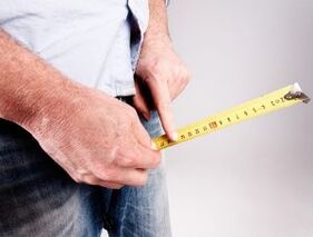 un uomo misura la lunghezza del pene prima di ingrandirlo con la soda